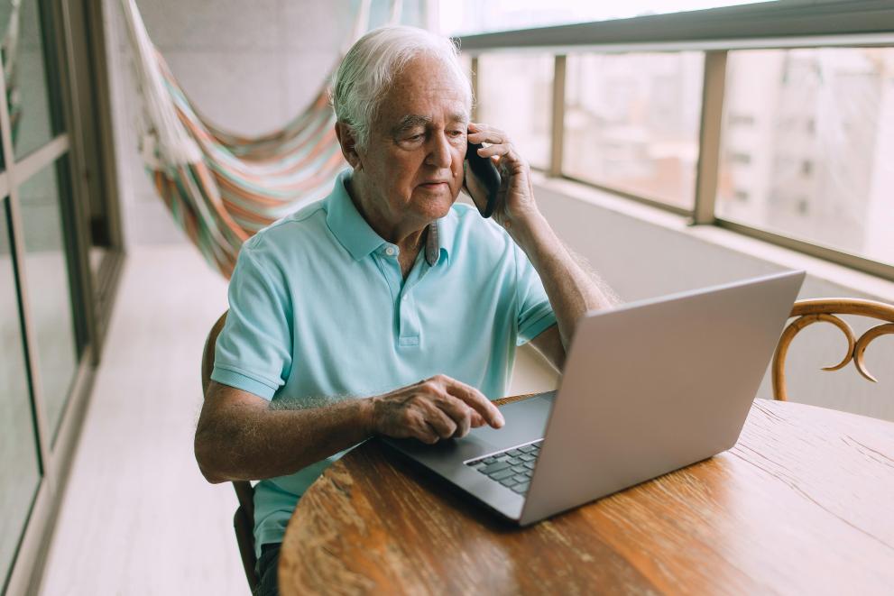 Old man with laptop and phone